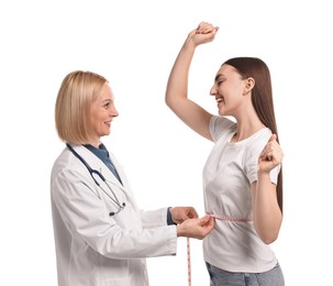 Happy woman lost weight. Nutritionist measuring patient's waist with tape on white background