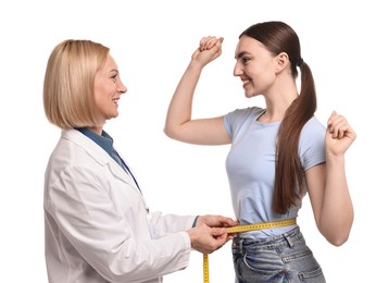 Photo of Happy woman lost weight. Nutritionist measuring patient's waist with tape on white background