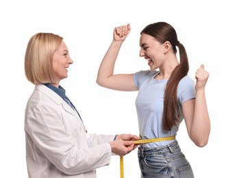 Photo of Happy woman lost weight. Nutritionist measuring patient's waist with tape on white background