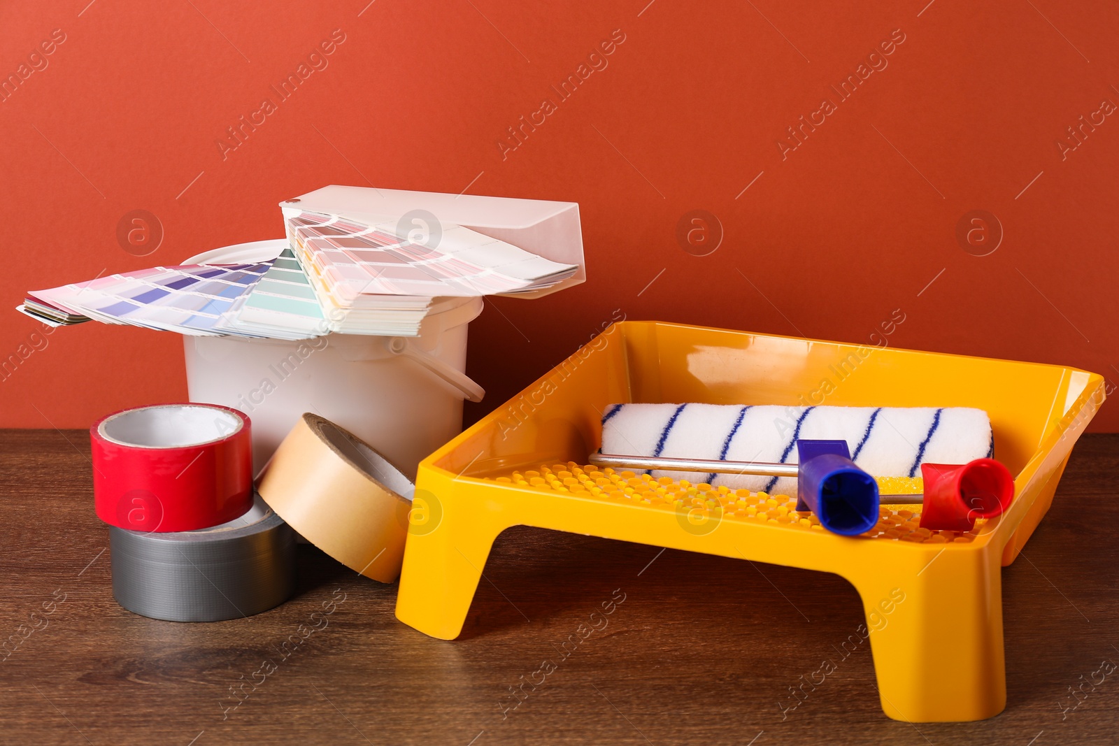 Photo of Different painter's tools on wooden table. Decorating and design