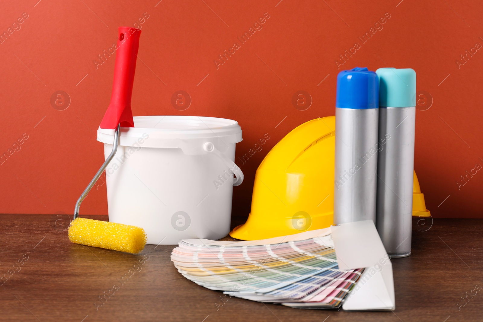 Photo of Different painter's tools on wooden table. Decorating and design