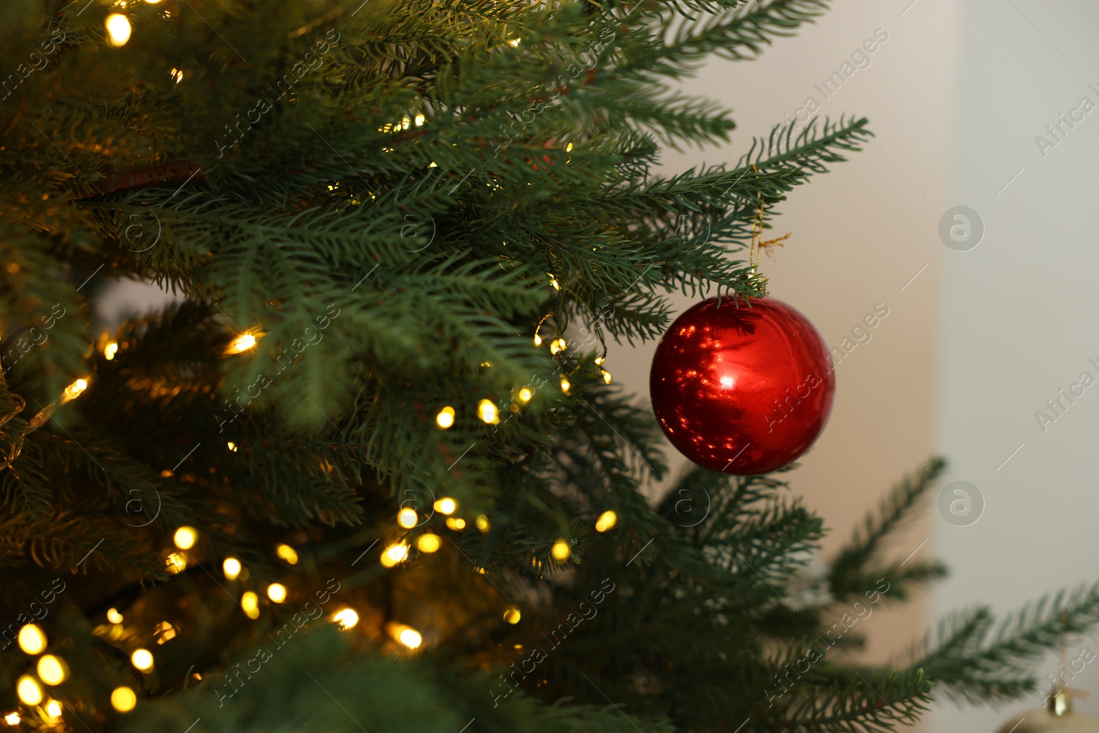 Photo of Christmas tree with beautiful lights and bauble indoors, closeup