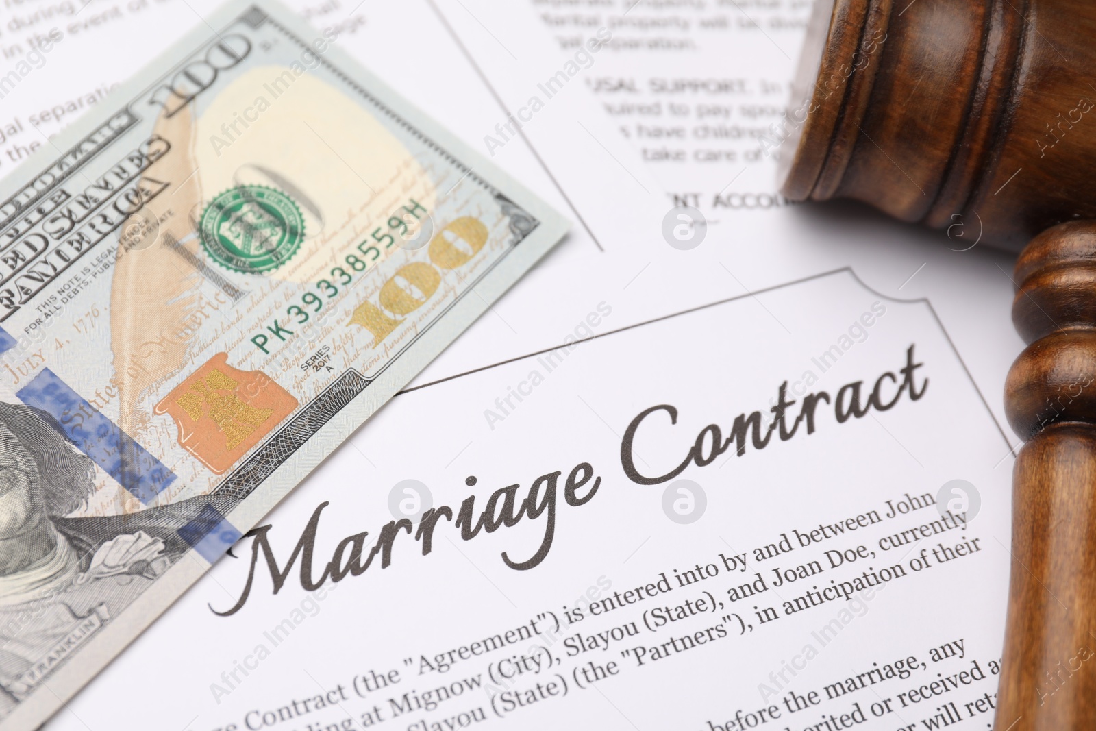 Photo of Marriage contract, gavel and dollar bill, closeup