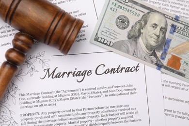 Photo of Marriage contract, gavel and dollar bill, top view