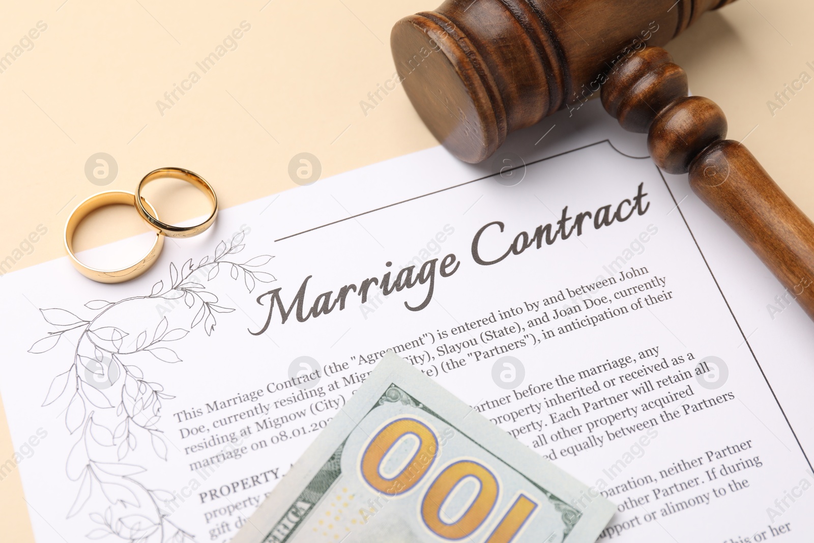 Photo of Marriage contract, gavel, dollar bill and golden rings on beige background, above view