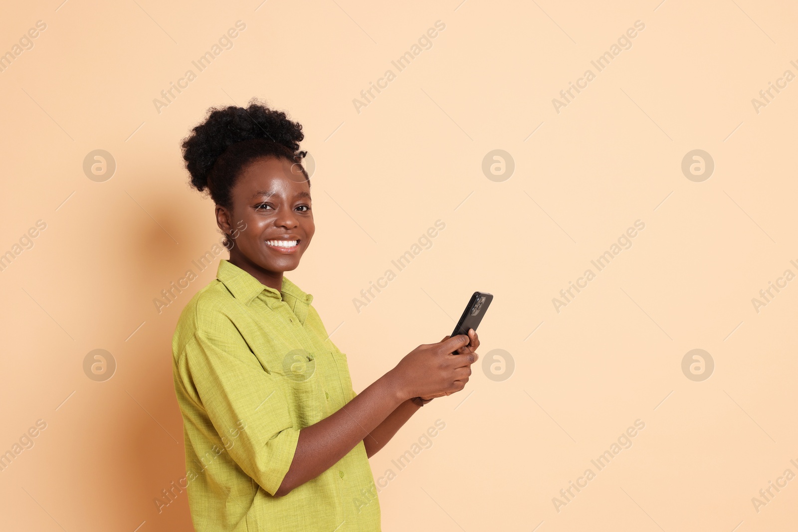 Photo of Happy woman with smartphone on beige background. Space for text