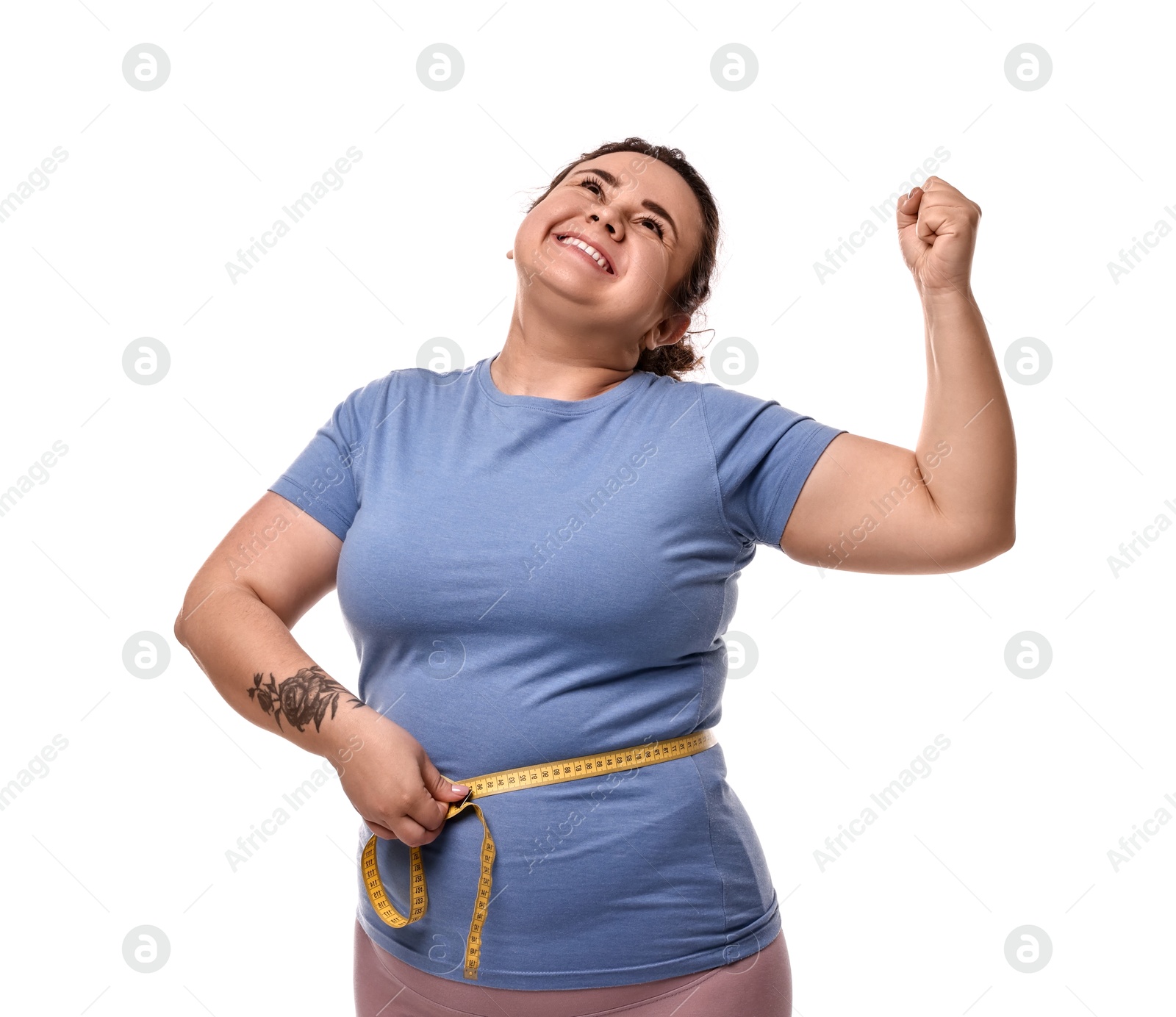 Photo of Weight loss. Happy plus size woman measuring waist with tape on white background