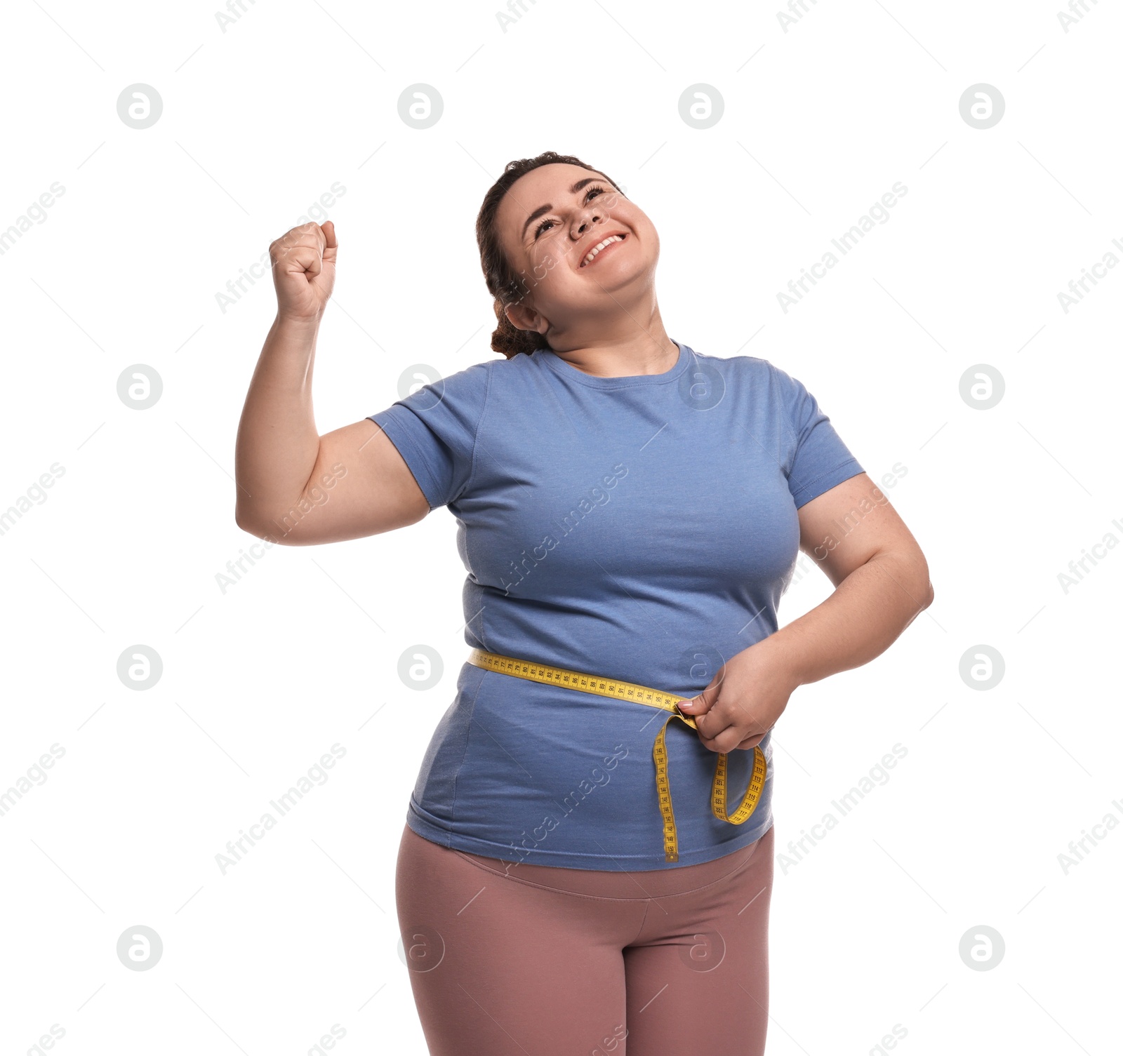 Photo of Weight loss. Happy plus size woman measuring waist with tape on white background