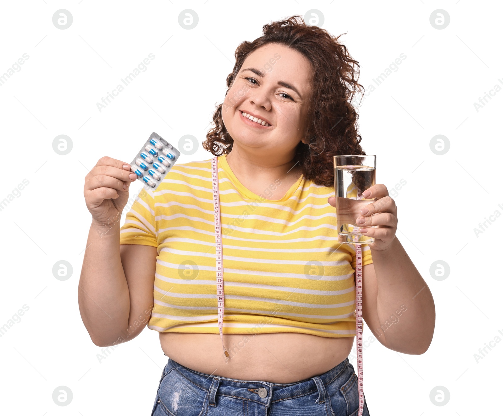 Photo of Happy plus size woman holding blister of weight loss supplements and glass of water on white background