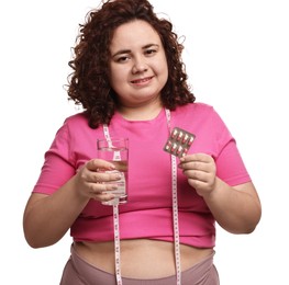 Photo of Happy plus size woman holding blister of weight loss supplements and glass of water on white background