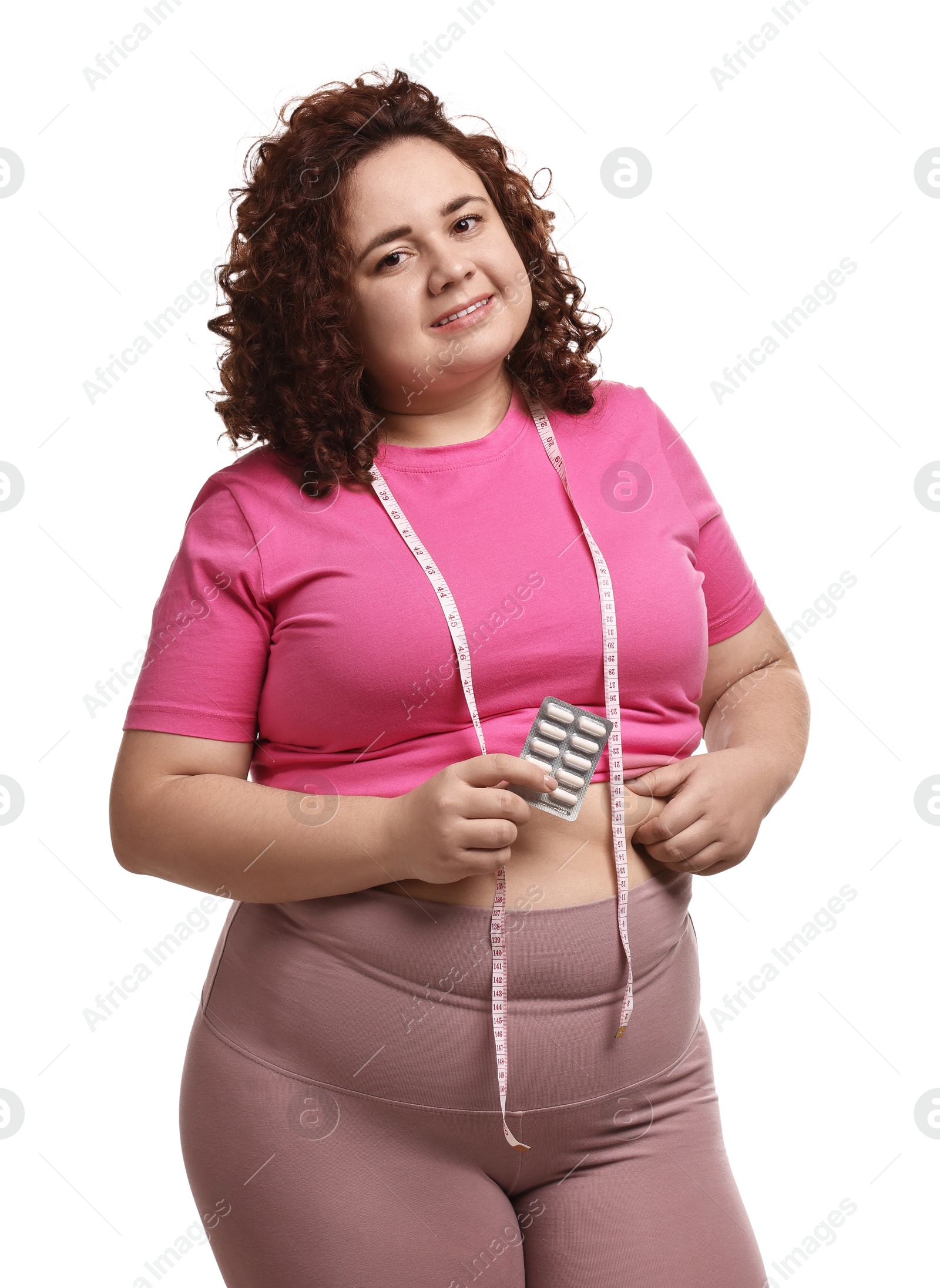 Photo of Happy plus size woman holding blister of weight loss supplements on white background