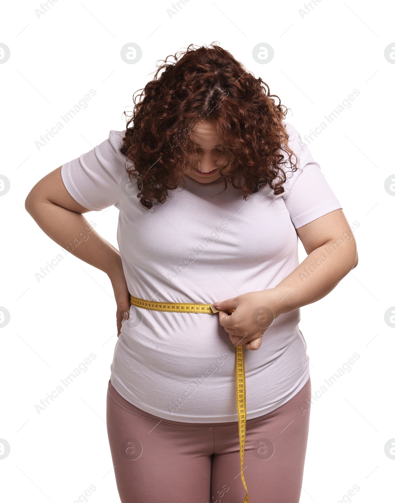 Photo of Weight loss. Plus size woman measuring waist with tape on white background