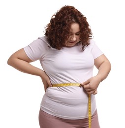 Photo of Weight loss. Plus size woman measuring waist with tape on white background