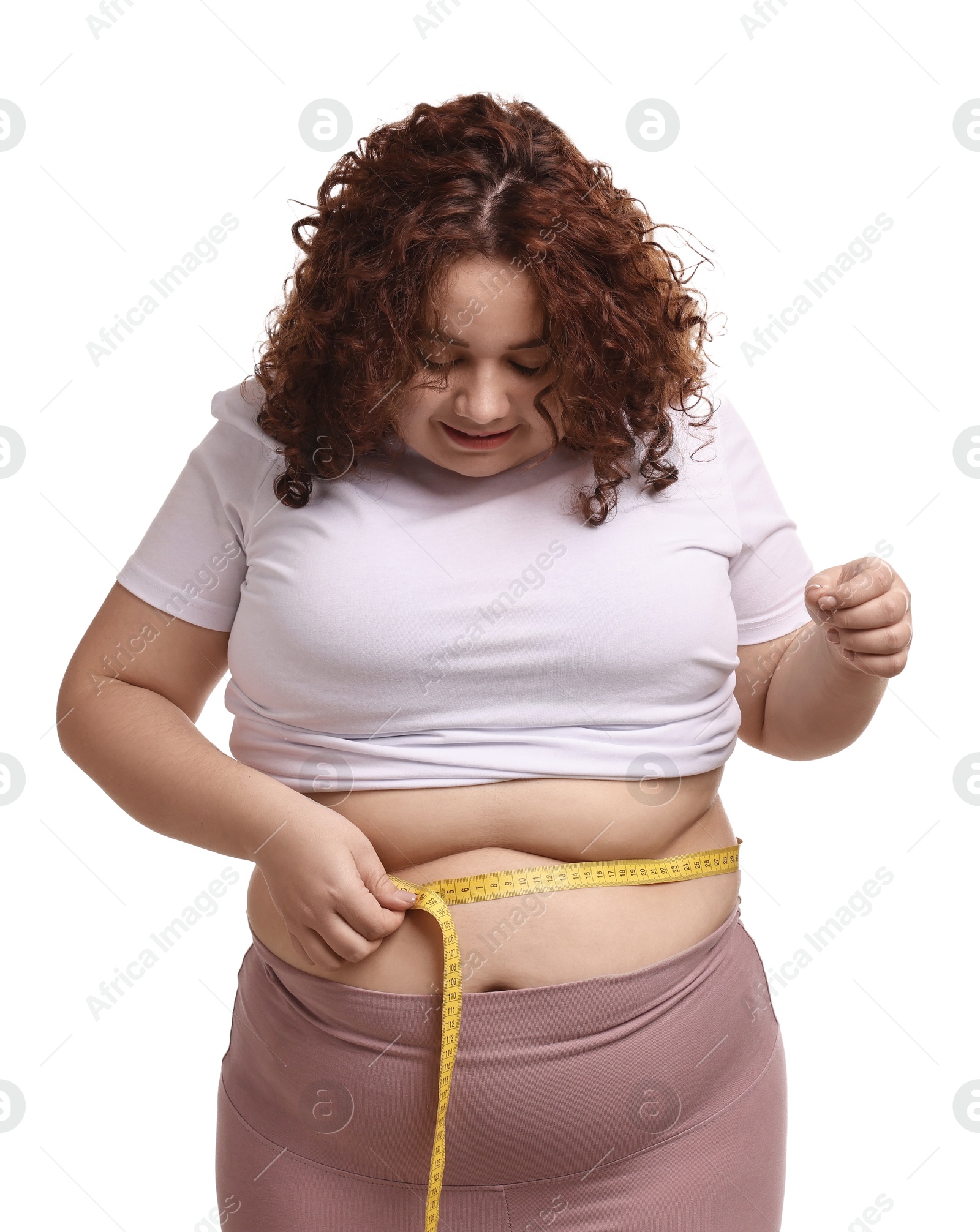 Photo of Weight loss. Plus size woman measuring waist with tape on white background