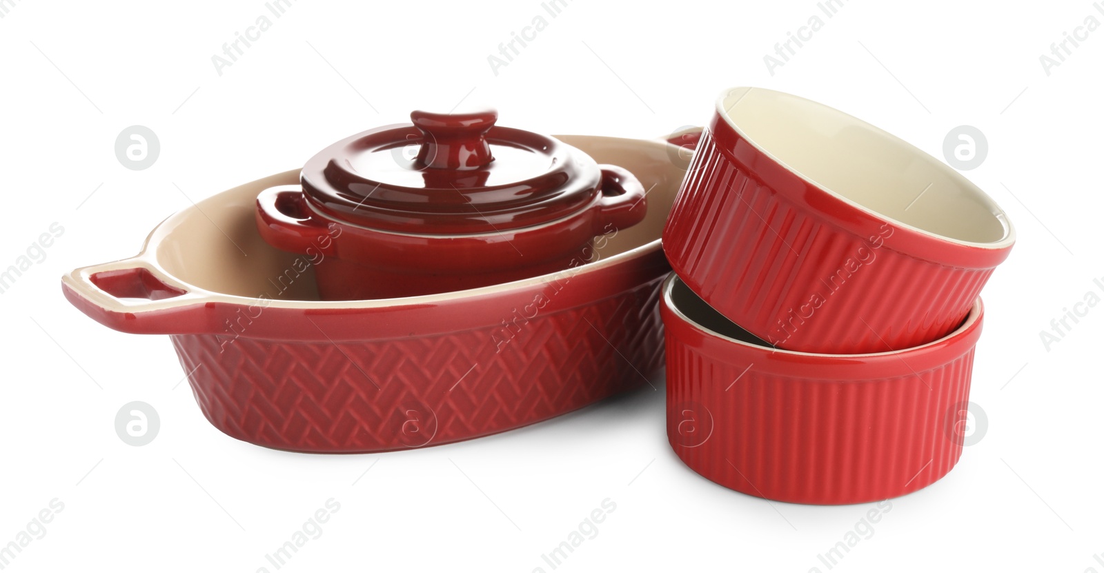 Photo of Different red casseroles isolated on white. Cooking utensil