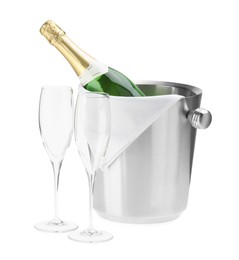 Photo of Bottle of champagne in ice bucket and empty glasses isolated on white