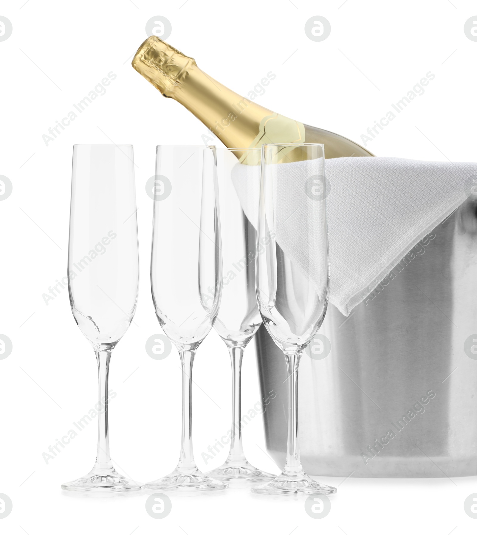 Photo of Bottle of champagne in ice bucket and empty glasses isolated on white