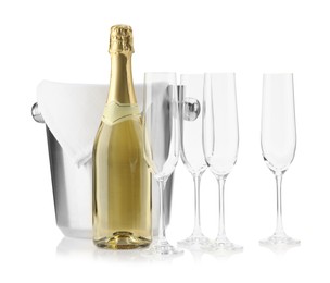 Photo of Bottle of champagne, ice bucket and empty glasses isolated on white