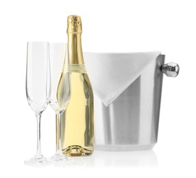 Photo of Bottle of champagne, ice bucket and empty glasses isolated on white