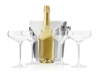 Photo of Bottle of champagne, empty glasses and ice bucket isolated on white