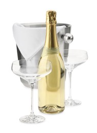 Photo of Bottle of champagne, empty glasses and ice bucket isolated on white