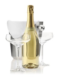 Photo of Bottle of champagne, empty glasses and ice bucket isolated on white