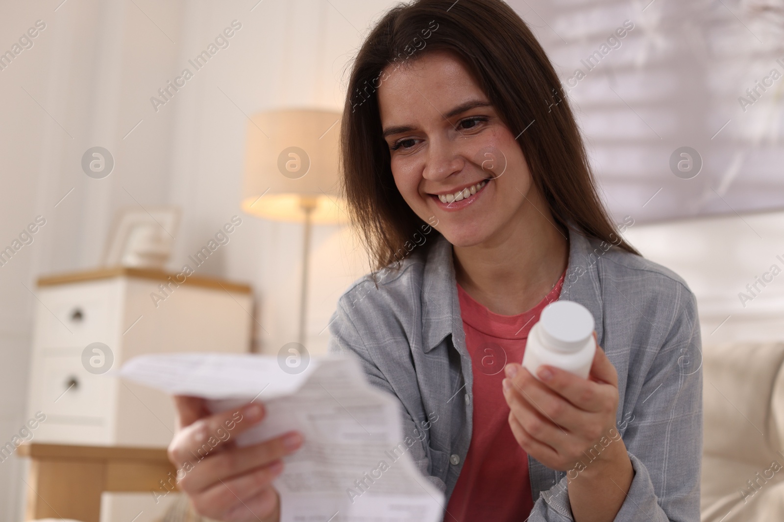 Photo of Woman with pills reading instruction at home