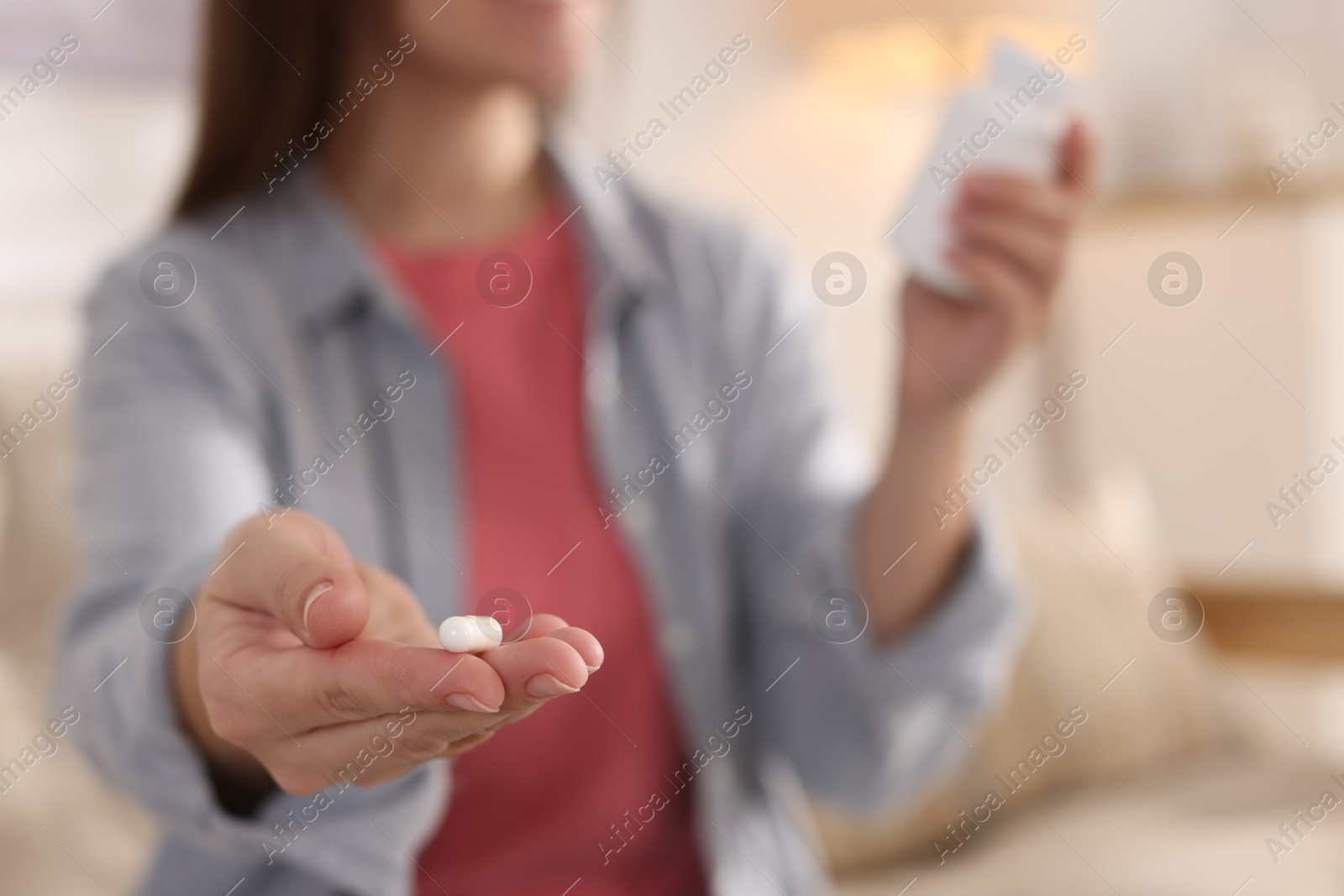 Photo of Woman with pill reading instruction at home, selective focus