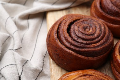 Photo of Delicious cinnamon roll buns on table, closeup