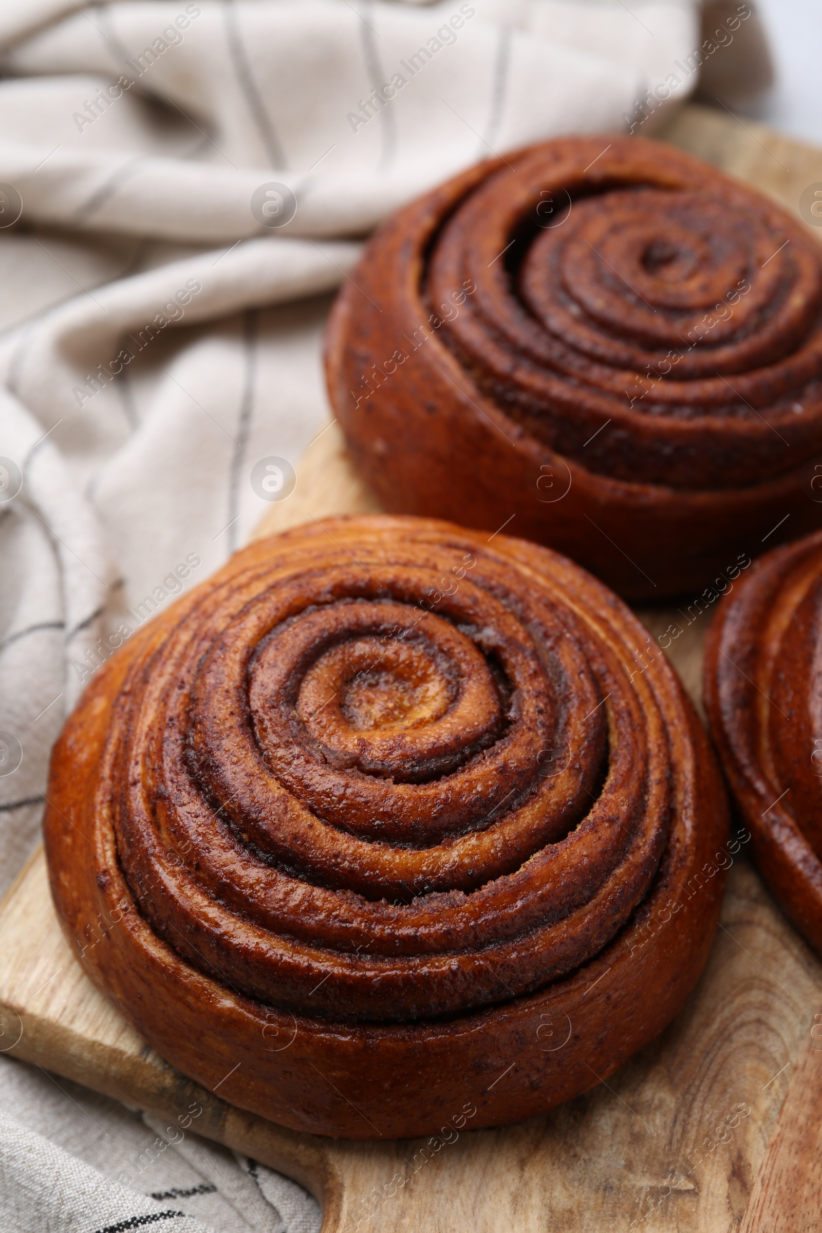 Photo of Delicious cinnamon roll buns on table, closeup