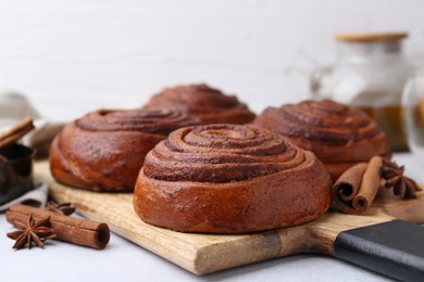 Photo of Delicious cinnamon roll buns on light table, closeup