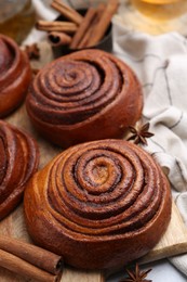 Photo of Delicious cinnamon roll buns on table, closeup