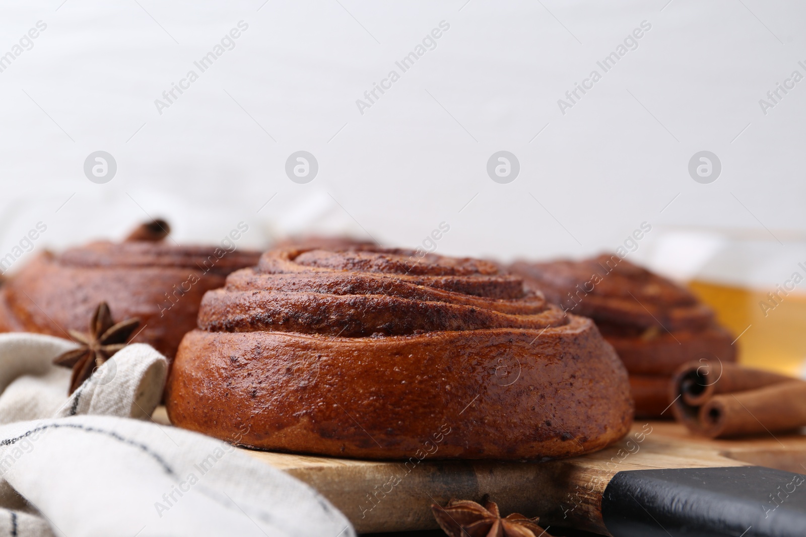 Photo of Delicious cinnamon roll buns on table, closeup