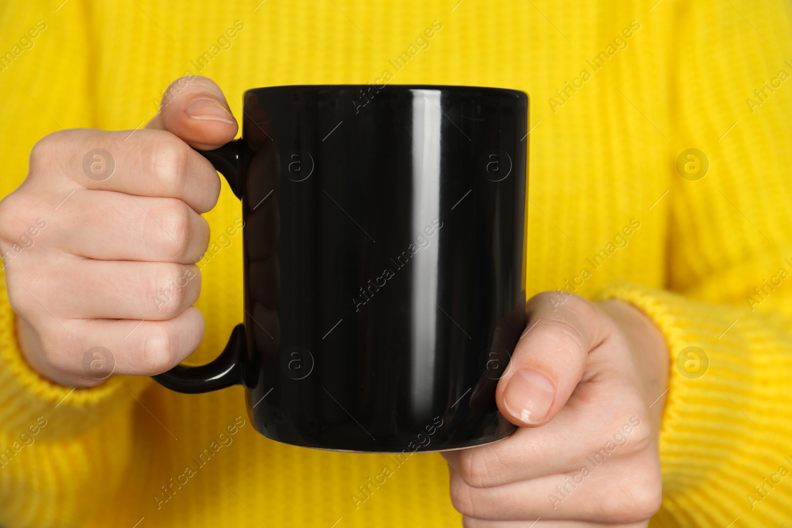 Photo of Woman with black ceramic cup, closeup. Mockup for design