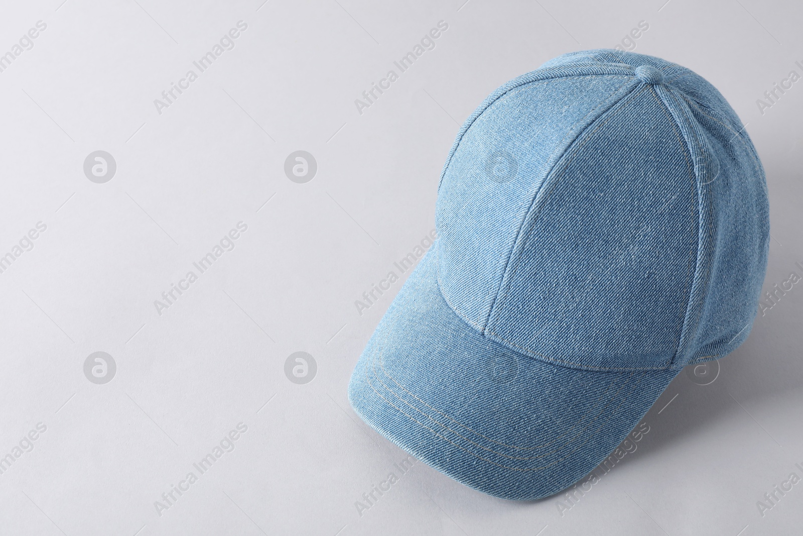 Photo of Stylish denim baseball cap on light grey background. Mockup for design