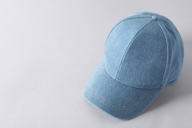 Photo of Stylish denim baseball cap on light grey background. Mockup for design