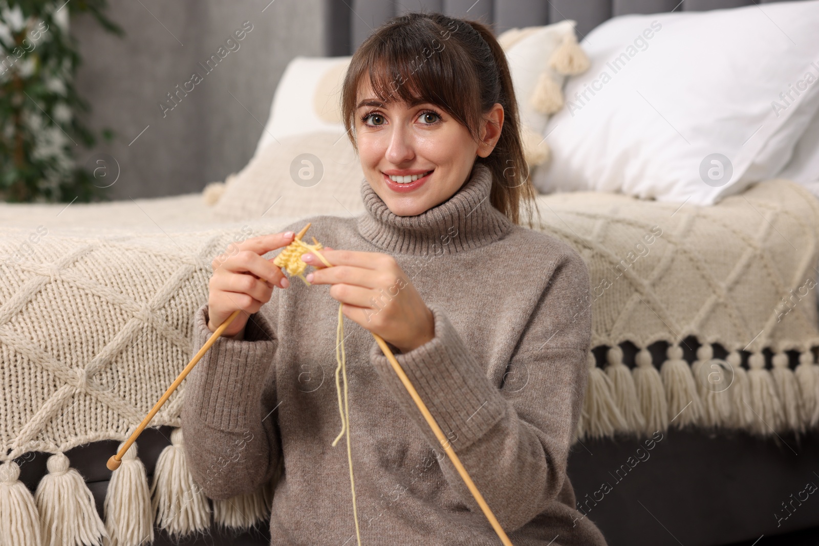 Photo of Beautiful woman knitting with needles at home