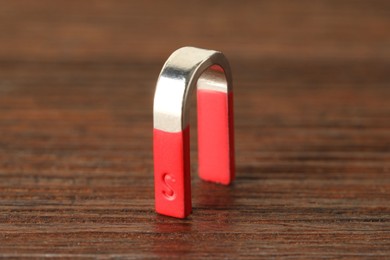 Photo of One horseshoe magnet on wooden table, closeup