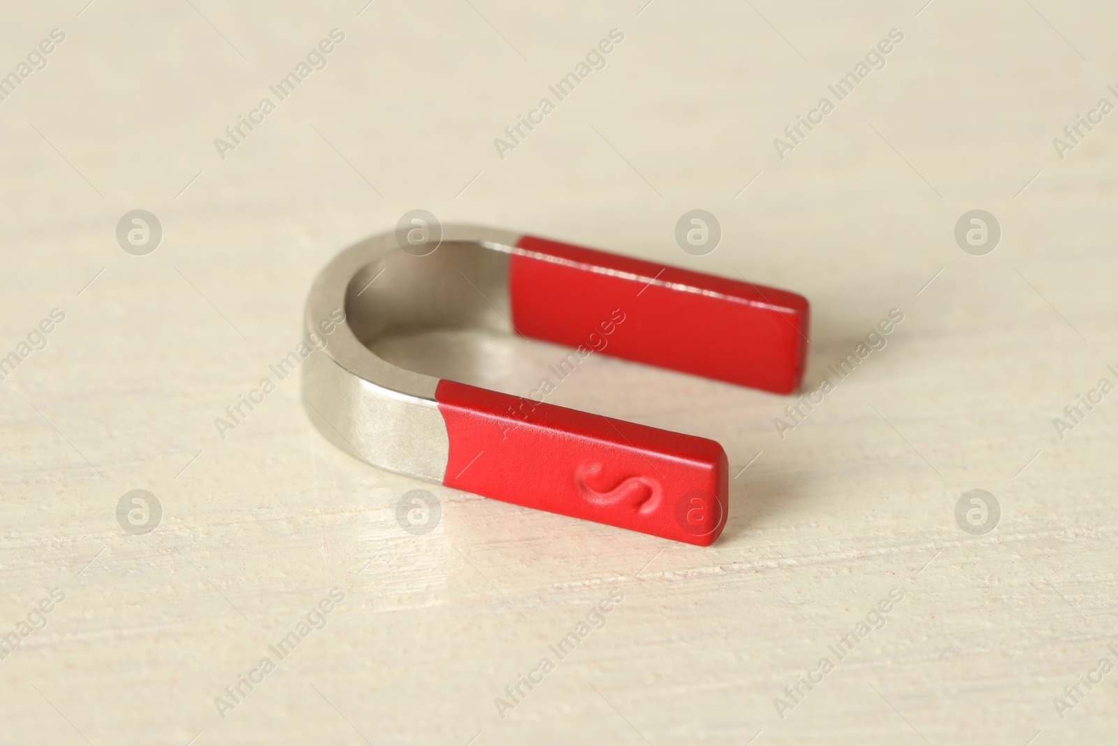 Photo of One horseshoe magnet on white wooden table, closeup