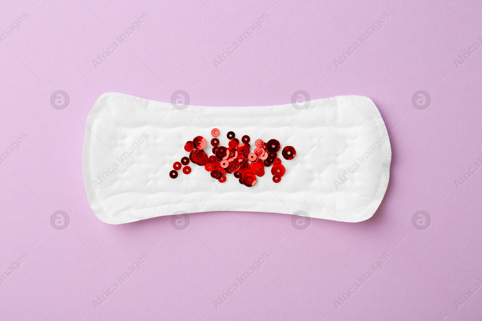 Photo of Menstrual pad with sequins on lilac background, top view