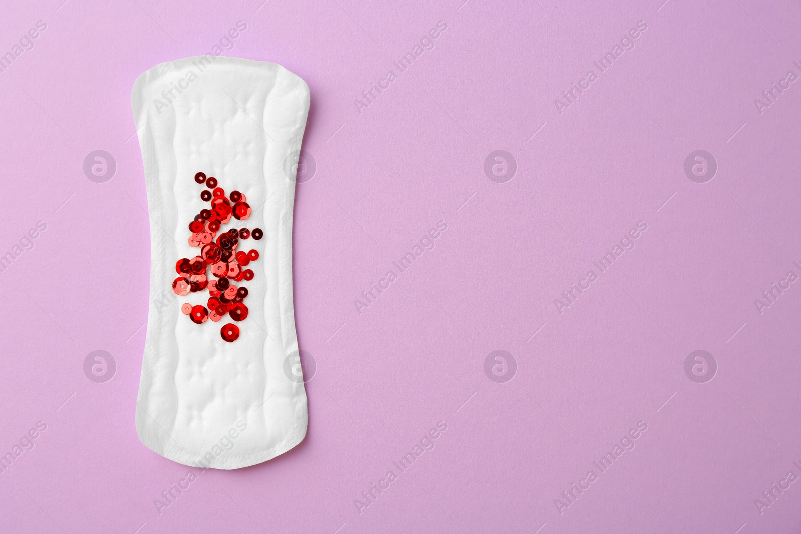 Photo of Menstrual pad with sequins on lilac background, top view. Space for text