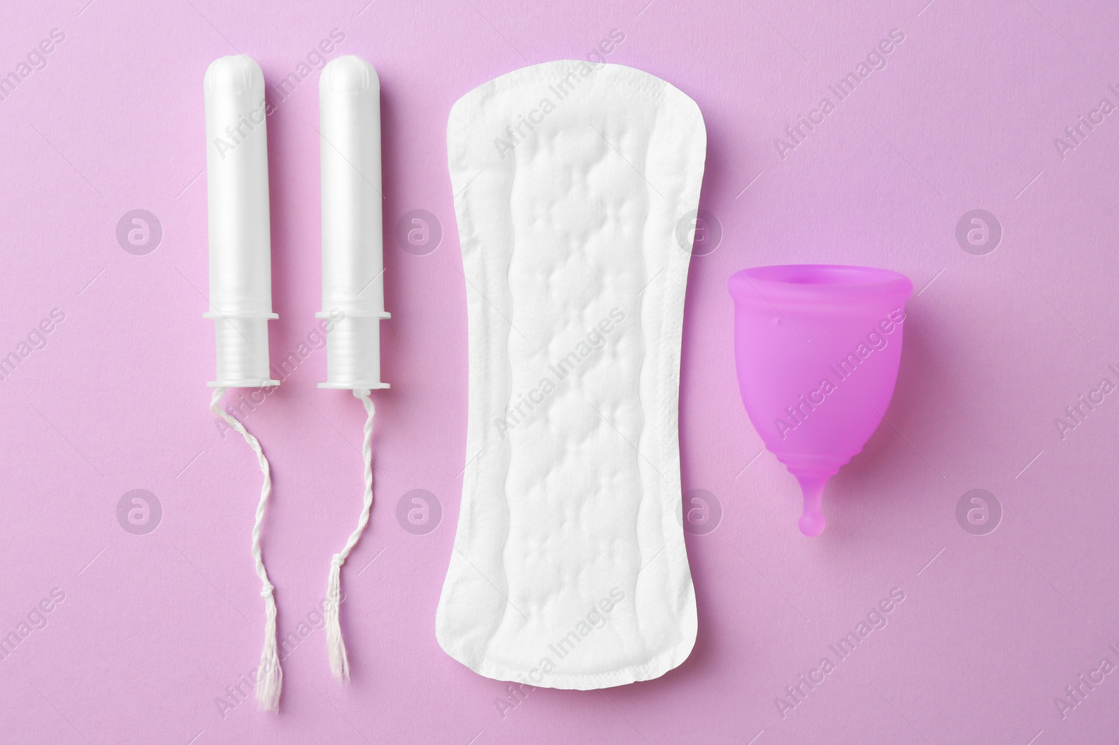 Photo of Menstrual pad, cup and tampons on lilac background, flat lay