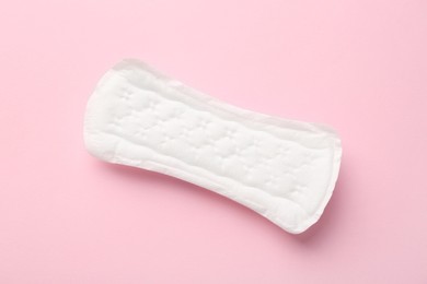 Photo of Menstrual pad on light pink background, top view