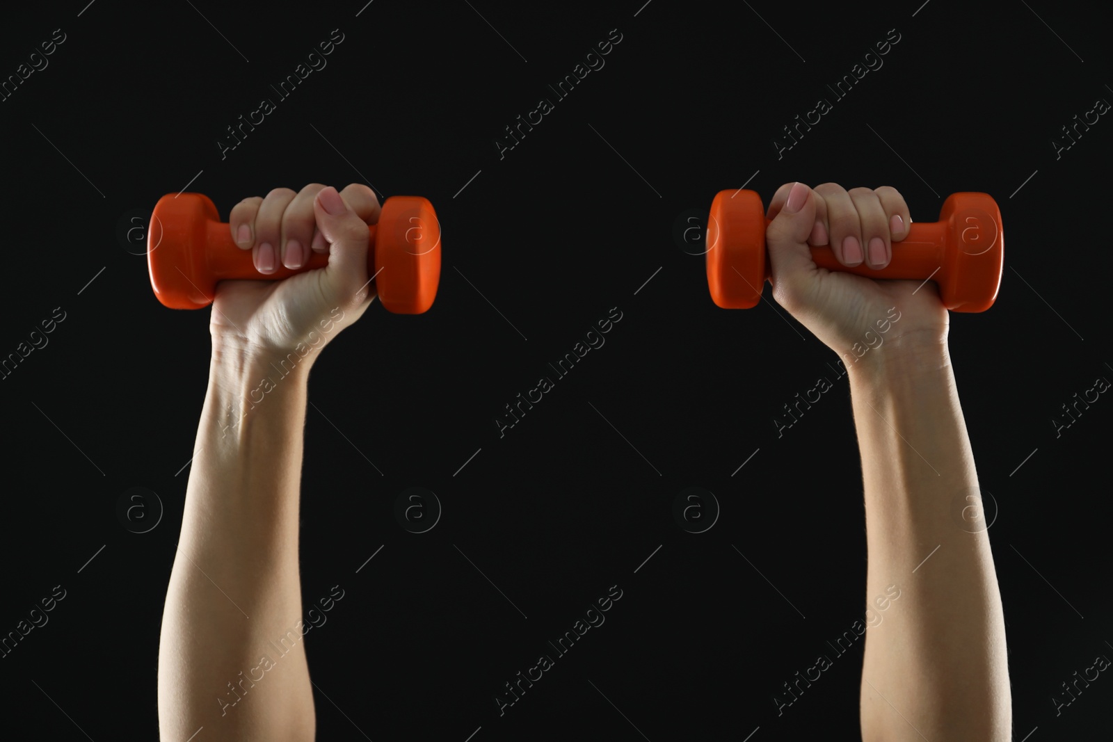 Photo of Woman exercising with dumbbells on black background, closeup