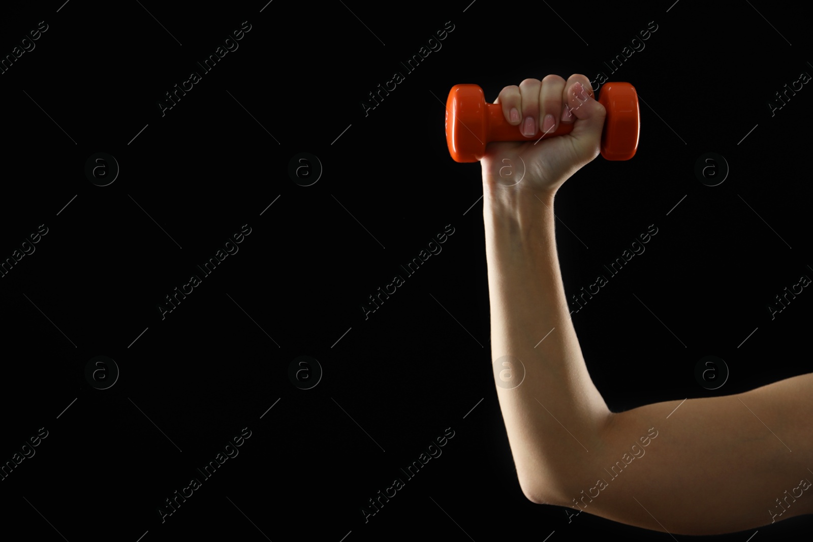 Photo of Woman exercising with dumbbell on black background, closeup. Space for text