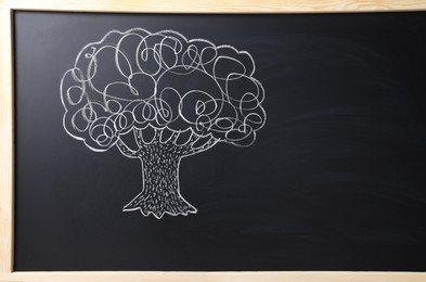 Photo of Beautiful drawing of tree on black chalkboard. Space for text