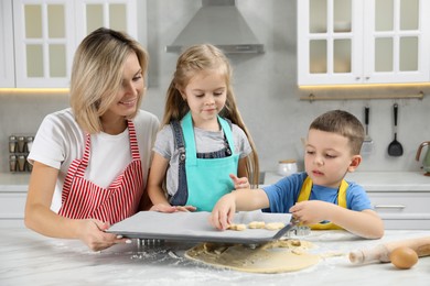 Photo of Children helping their mom making cookies in kitchen at home