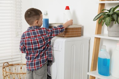 Little helper. Cute boy doing laundry at home