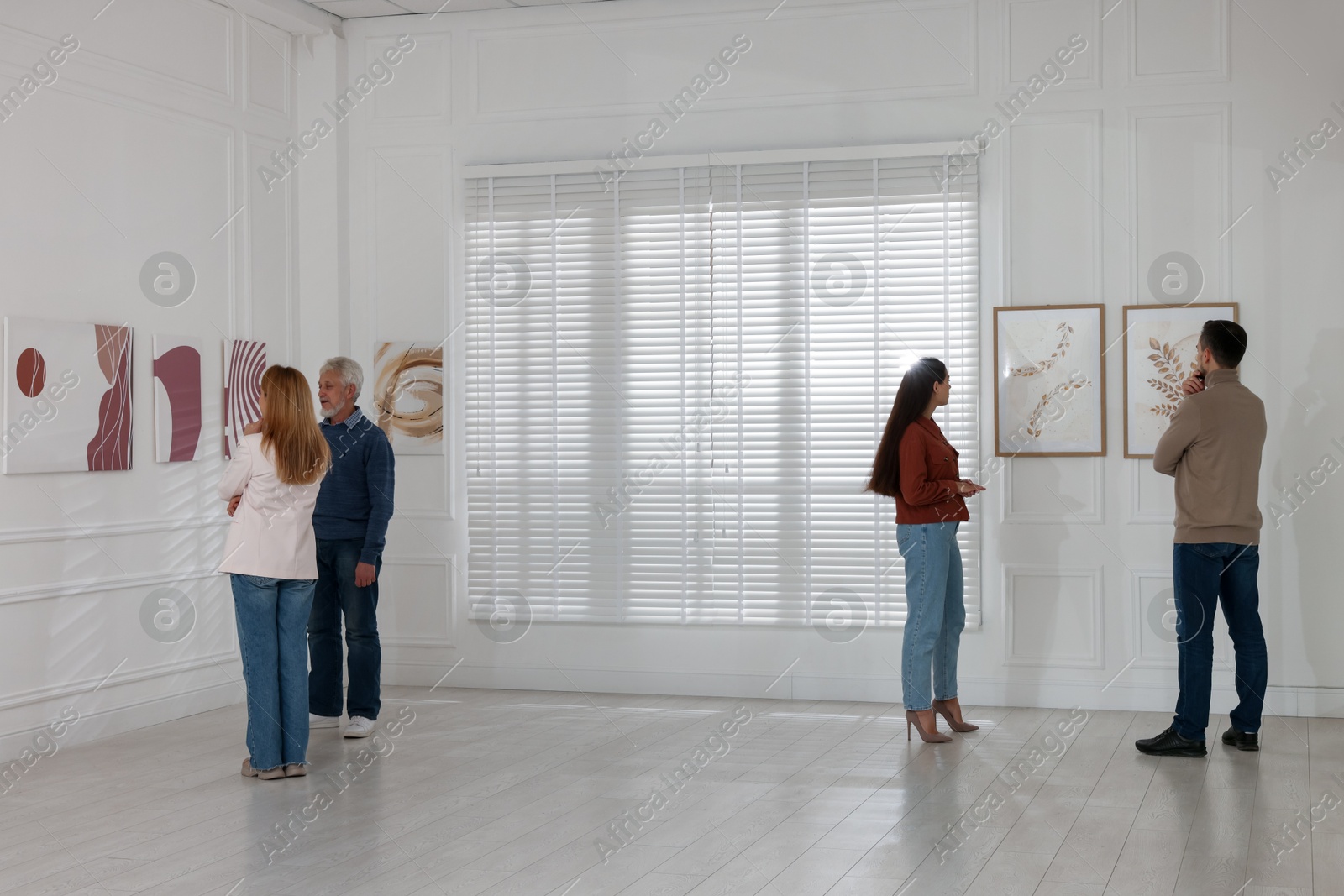 Photo of People studying beautiful art during event in gallery