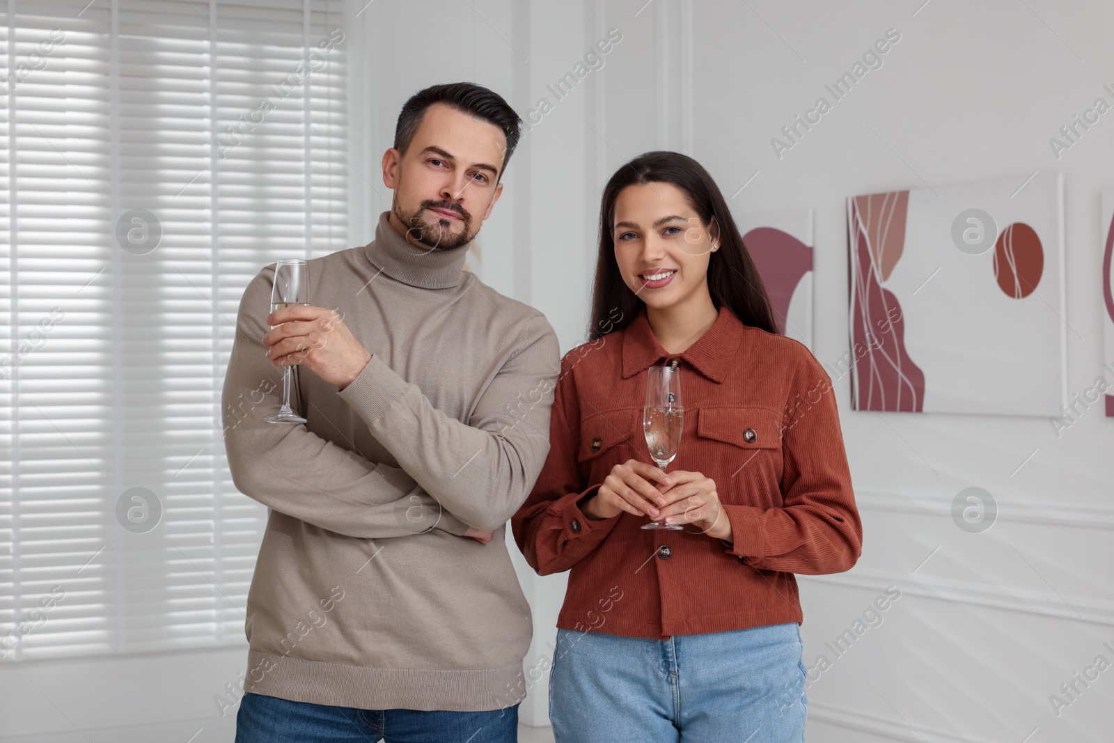 Photo of Couple enjoying art and sparkling wine in gallery